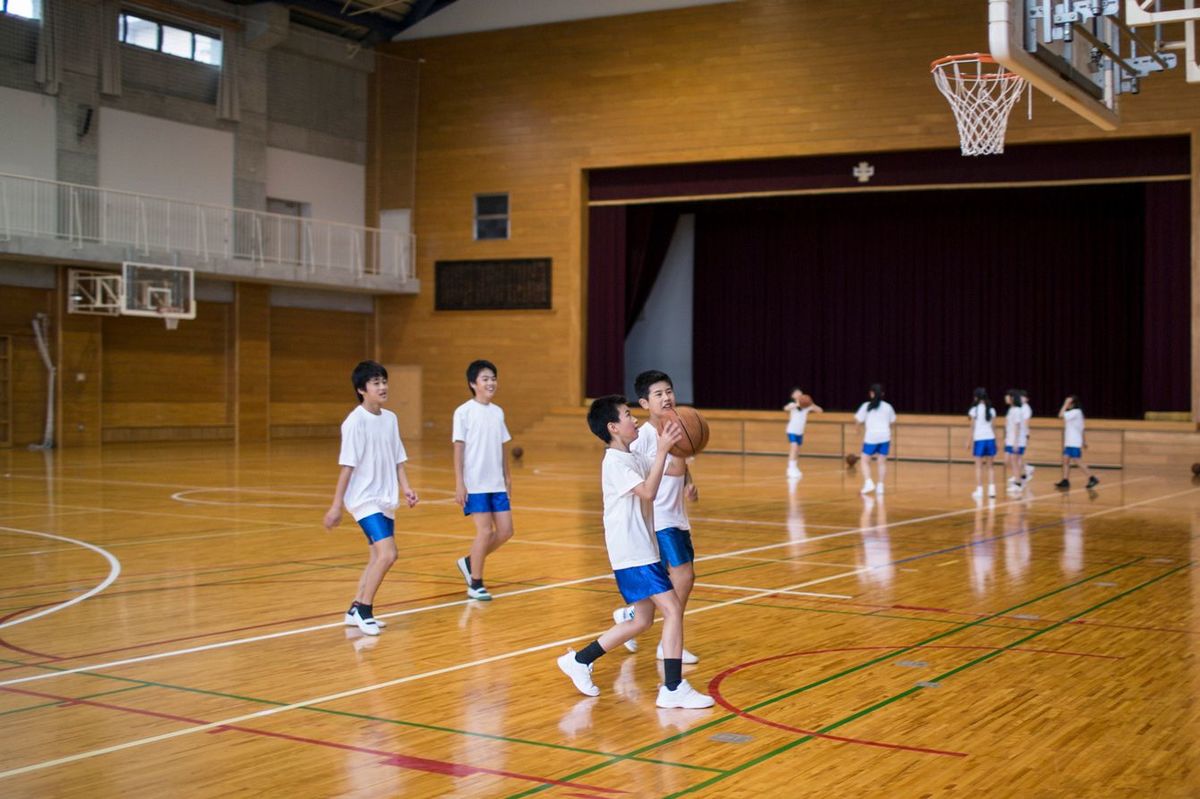 体育館でバスケットボールの練習をする子供たち