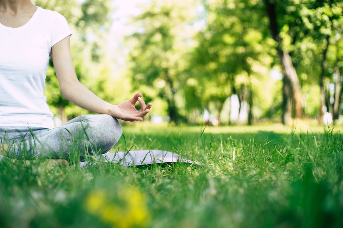 公園の芝の上で、ヨガの呼吸で瞑想