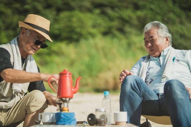 定年を過ぎた年配の男性は、砂浜でリラックスして趣味を楽しんでいます