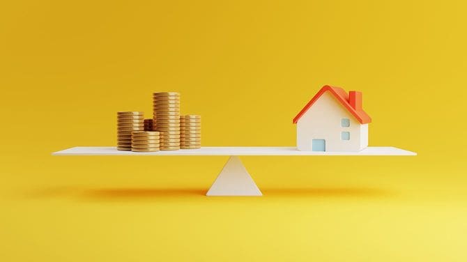 スケールのバランスをとって家とコイン