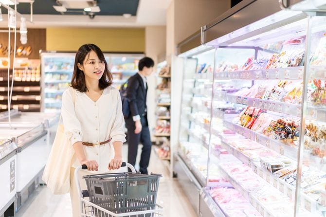 スーパーマーケットで食料品を買う若い女性