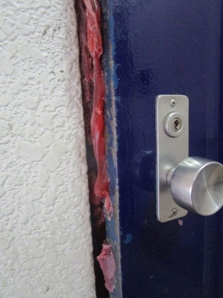 玄関ドアには赤いボンドを塗布したような跡があった。