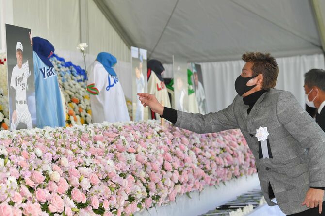 野村克也さんをしのぶ会で、献花の際に祭壇に向かって花を投げる日本ハムの新庄剛志監督＝2021年12月11日、神宮球場