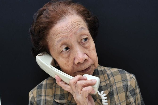 電話で受け答えするシニア女性