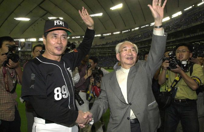 試合終了後、握手しながら笑顔で観客の声援にこたえるダイエーの王貞治監督(左)と中内〓(=2000年10月22日、東京ドーム)※〓は功の力が刀
