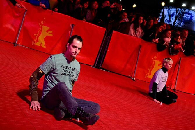 ベルリン国際映画祭2023の会場で、レッドカーペットに自らの手を接着して座り込むドイツの環境団体「最後の世代（LG）」の活動家（2023年2月16日）