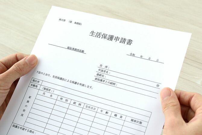 日本の公的支援申請書を持つ人間の手