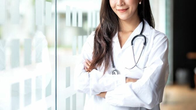 白衣を着た笑顔のアジア人女性医師