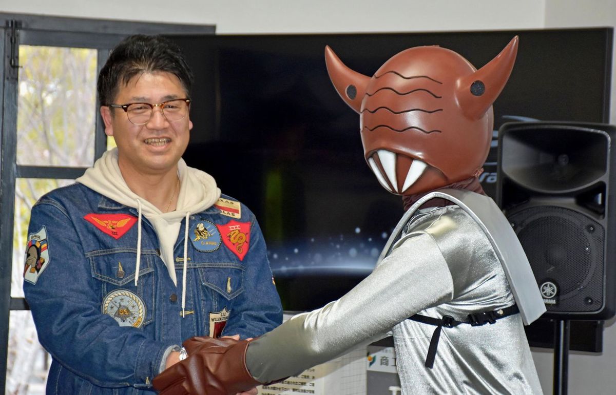 「甲府星人」と握手する「甲府UFO事件」の目撃者・山畠克博さん=2024年2月、甲府市