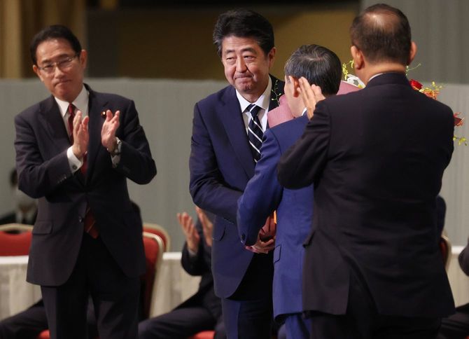 両院議員総会で菅義偉官房長官から花束を受け取る安倍晋三首相（左から2人目）。右端は石破茂元幹事長、左端は岸田文雄政調会長＝2020年9月14日午後、東京都港区