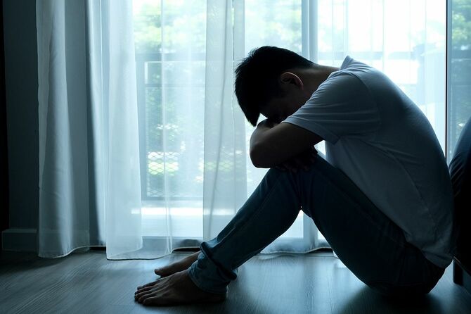 部屋の隅に座っている男