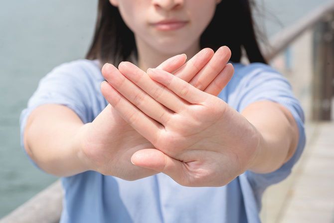 手のひらでバツ印を作る女性