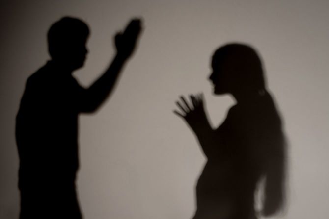 女性に手を上げる男性のシルエット