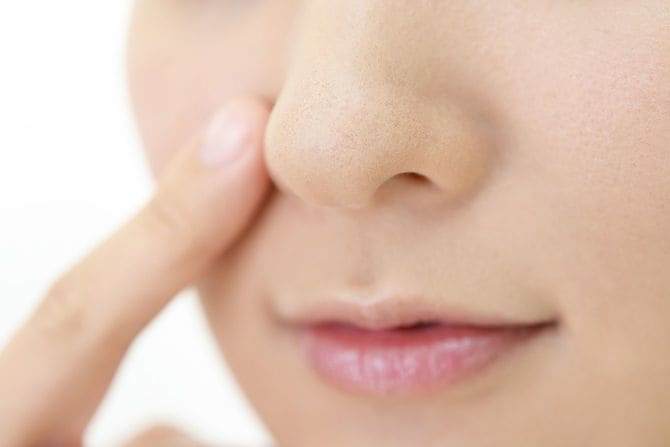 小鼻に指を添えている女性