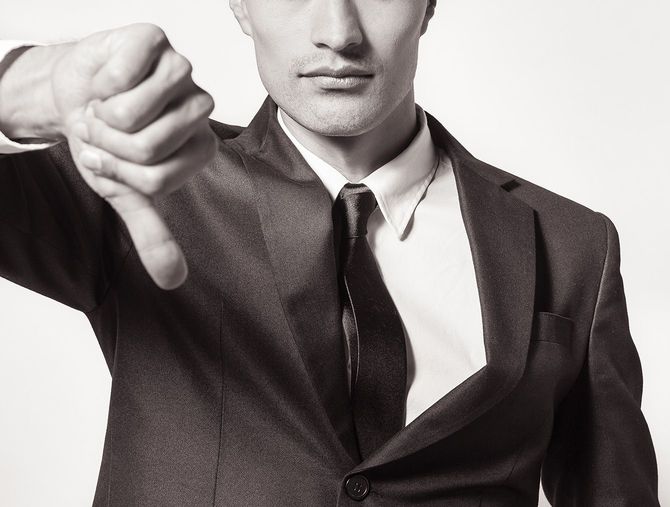 親指を下に向けるビジネスマン