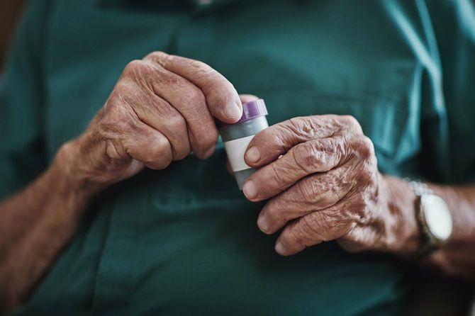 ふたを開けようとしているシニアの手元