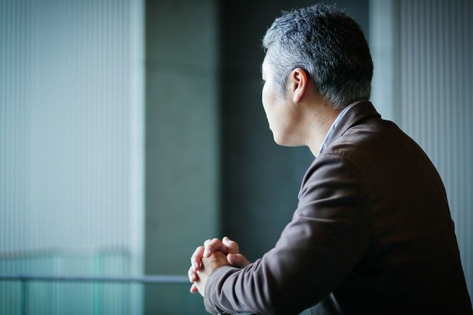 ぼんやり外を眺めるビジネスマン