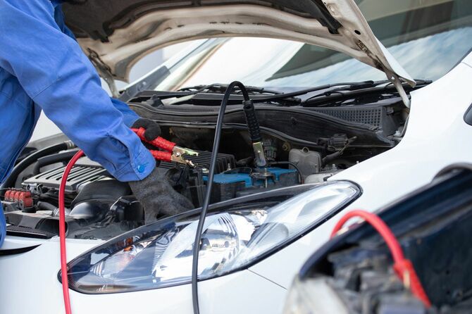 車のバッテリーを修理する整備士