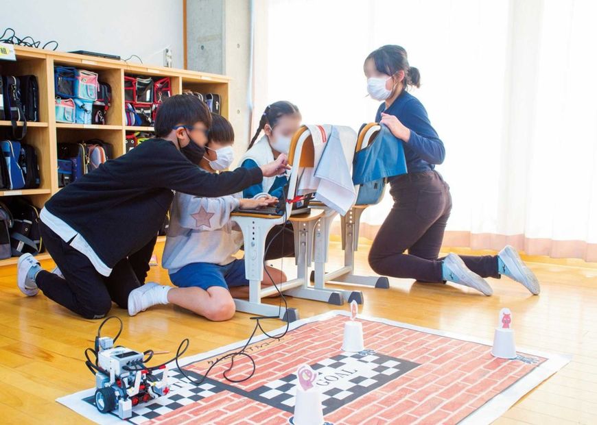 ロボットがゴールするまでのタイムを競う。思い通りに走ってくれずプログラムを修正中。真剣だ。