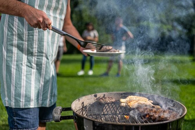 バーベキューでハンバーグを焼く男性