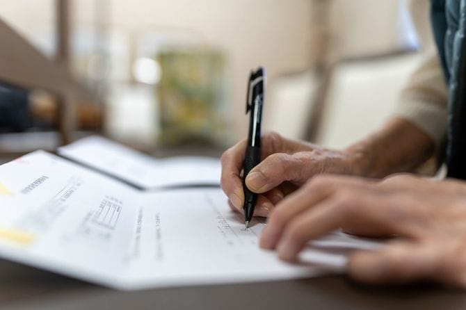 署名するシニアの手元