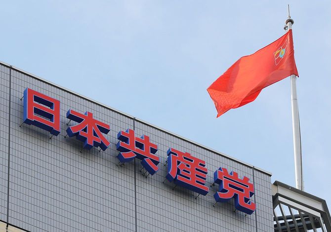 日本共産党本部ビルに設置されたロゴマーク看板と党旗(赤旗)=2016年7月10日