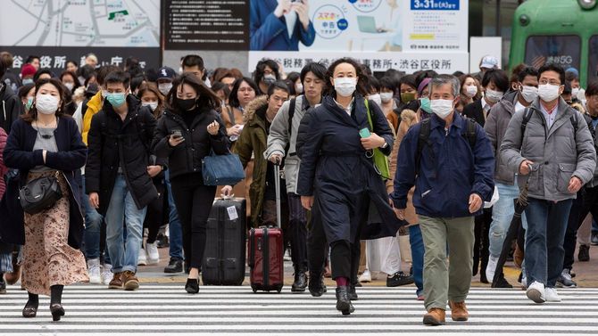 2020年2月22日、渋谷のスクランブル交差点をマスクを着けて歩く人々