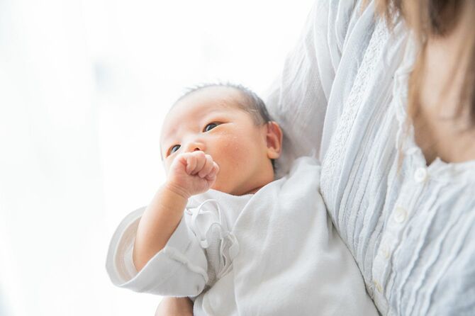 アジア人（日本人）の新生児を抱いた母親（生後0カ月）