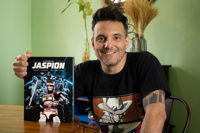 刊行されたばかりの決定版ジャスピオン図鑑を手にするヒカルド・クルーズさん