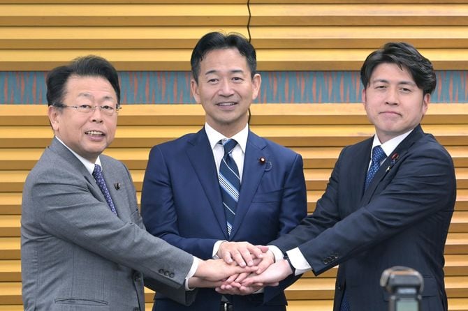 党大会後の記者会見で手を合わせる公明党の岡本三成代表ら