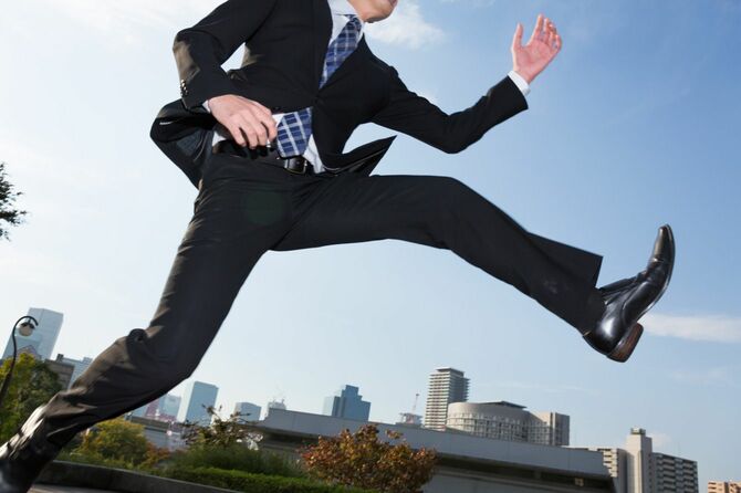 前に向かってジャンプするビジネスマン