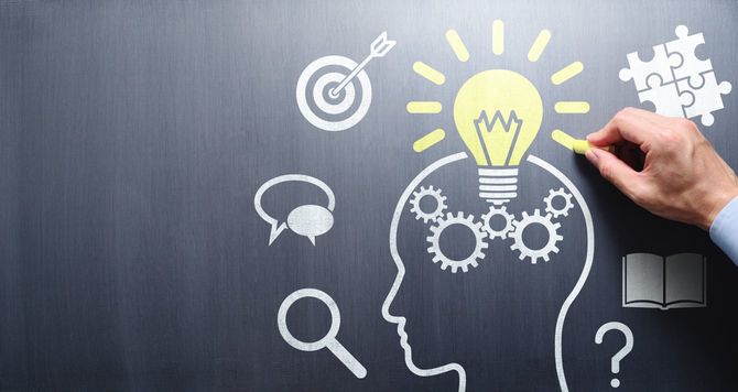 黒板に電球と頭のイメージを描いている写真