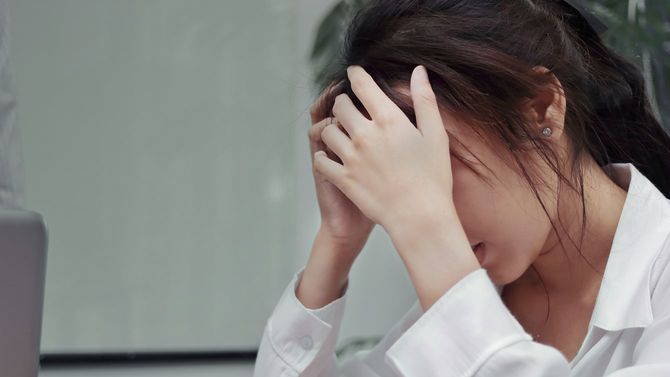 重度のストレスに頭を抱える女性