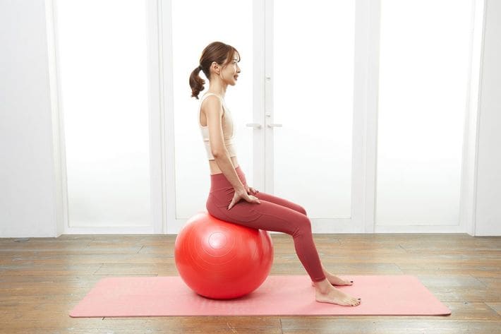 背筋を伸ばしてボールに座り、ひざ裏の角度は写真を参考に90～100度くらいを目安に