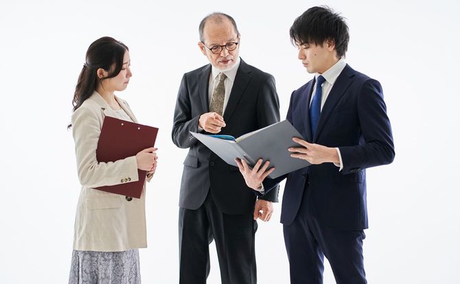 ファイルを見ながら指示するシニア上司