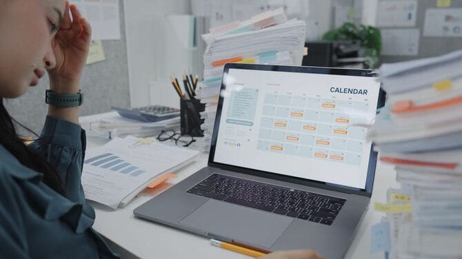 ぎっしり詰まったデジタルカレンダーを見ている疲れた女性