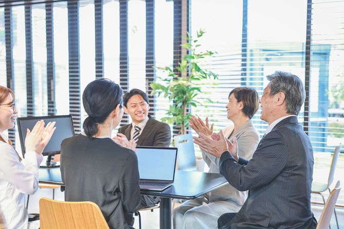 会議中に拍手するビジネスパーソン
