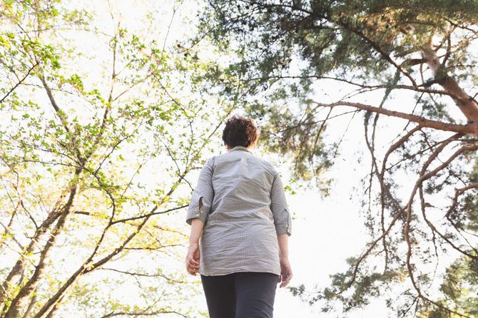 公園を歩いている年配の女性