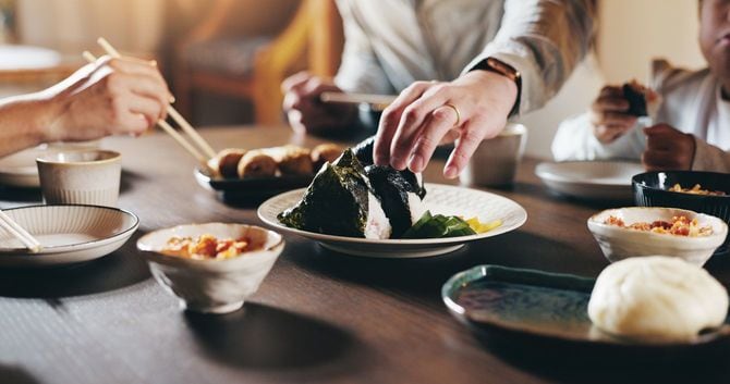 おにぎりなどの軽食をテーブルを囲み家族でとっている