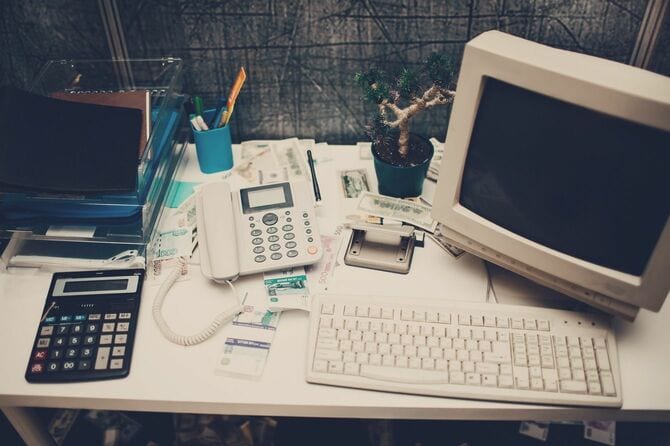 古いパソコンのあるオフィス内のデスク