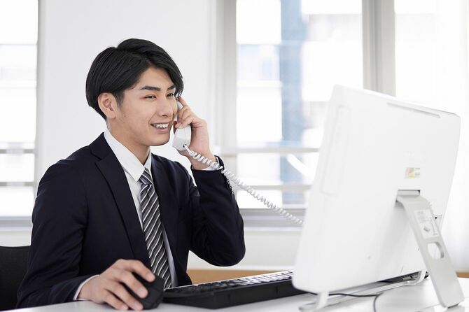 笑顔で電話に出る日本人男性ビジネスマン