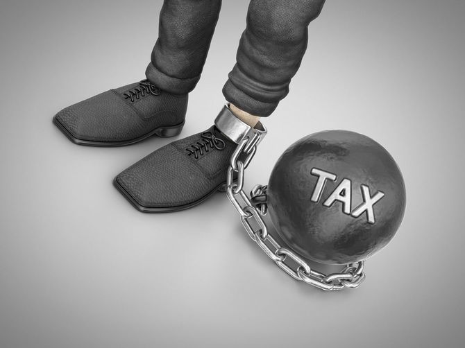 「税」という重いおもしにつながれた人の足元