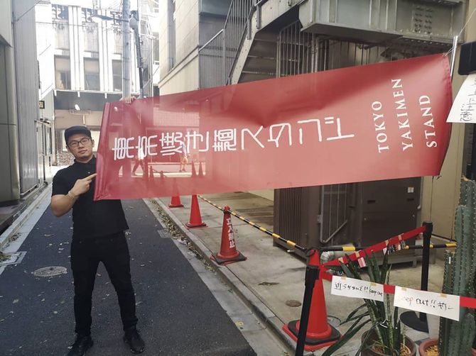 焼きそば店「焼き麺スタンド」ののぼりを掲げる黒田さん