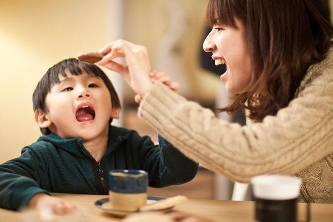 クッキーを使って遊ぶ母親と息子