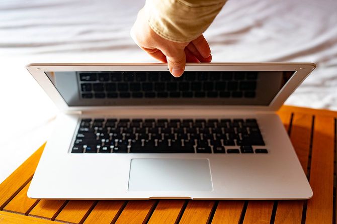 白いラップトップを閉じる手