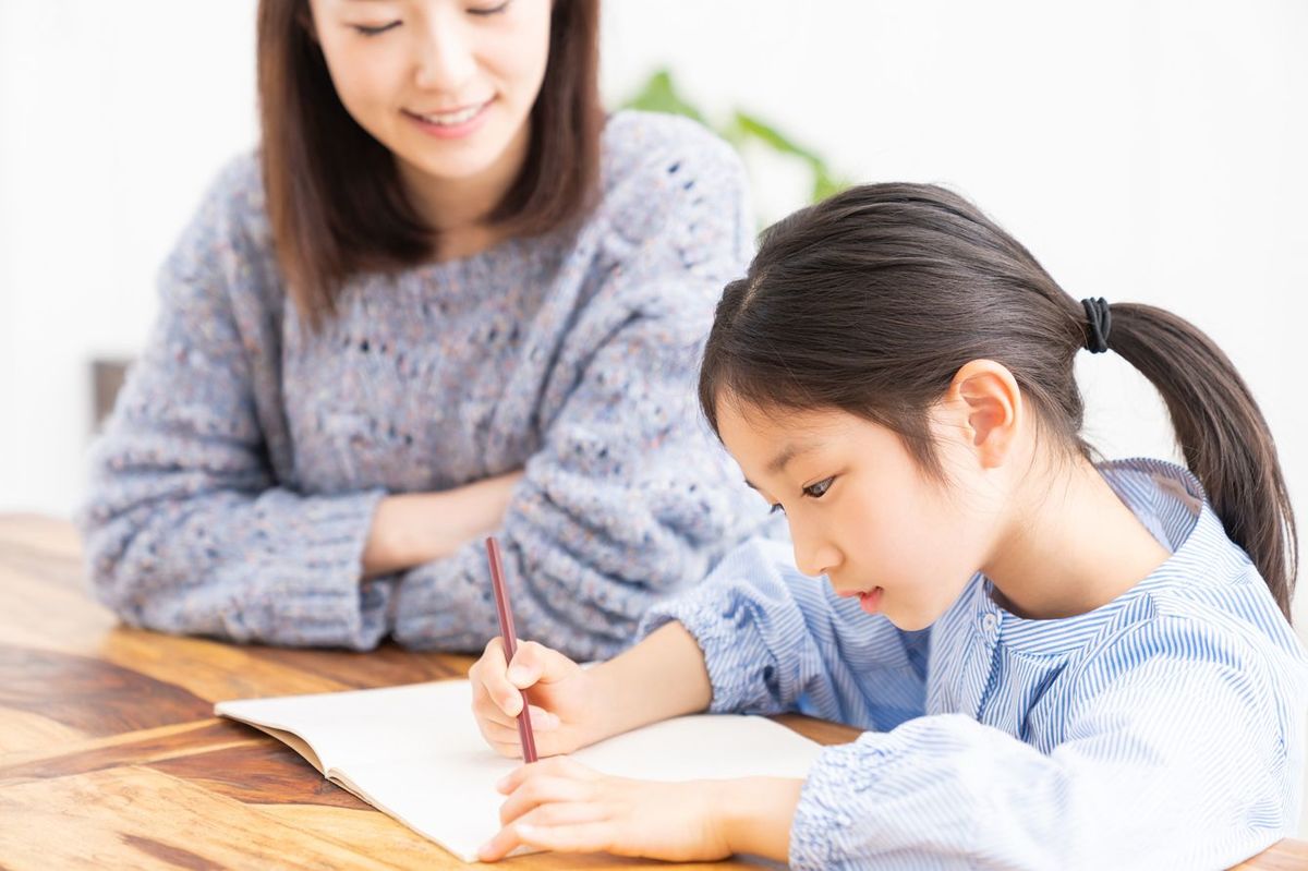 子どもの勉強に付き添う母親