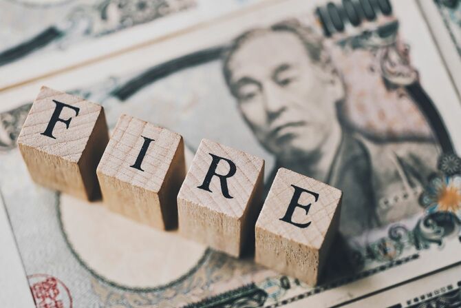 1万円札の上に、木製ブロックで「FIRE」の文字