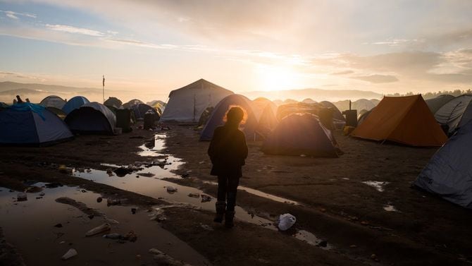 ギリシャ・イドメニの難民キャンプ。朝日を浴びる子供の眼前には数百のテントが並んでいる
