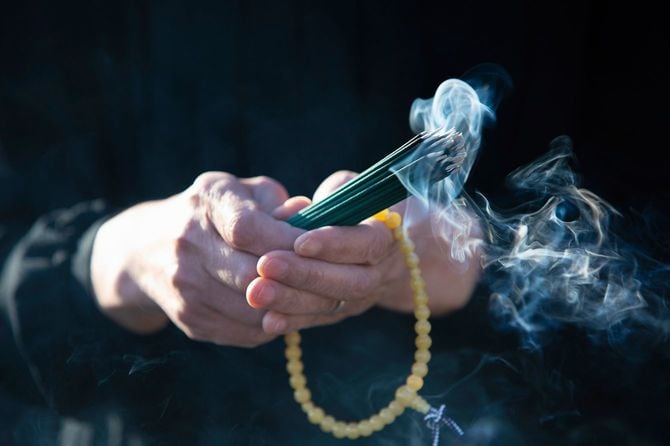 お線香を持つ女性の手