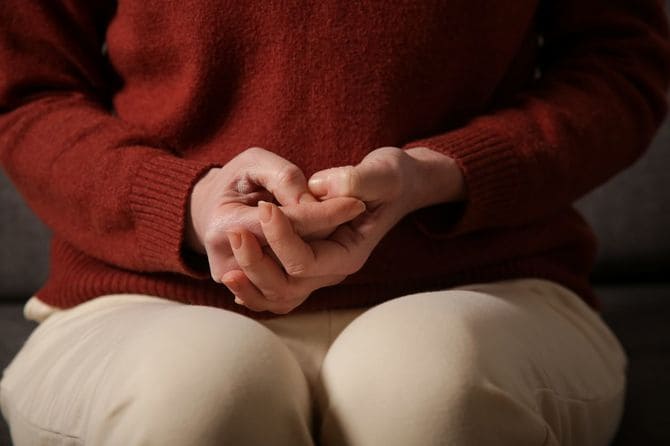 手を握り不安げな女性